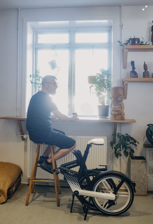 Person pedaling an under-desk bike exerciser while working at a home office desk