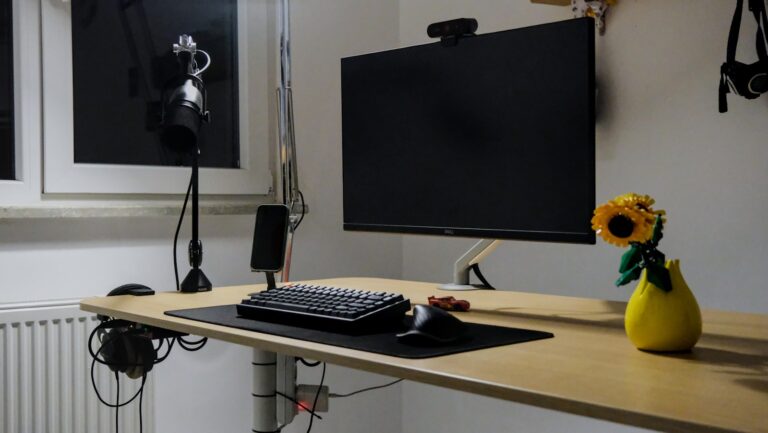 Home office desk setup with external webcam mounted on monitor